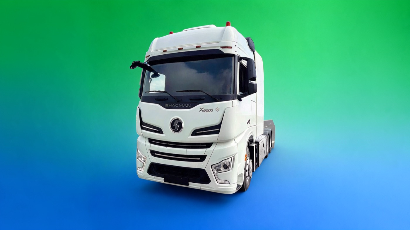 Shacman X6000 CNG en vista tres cuartos delantera: tractocamión 6x4 de cabina blanca con techo alto alargado y parrilla con el emblema Shacman.
